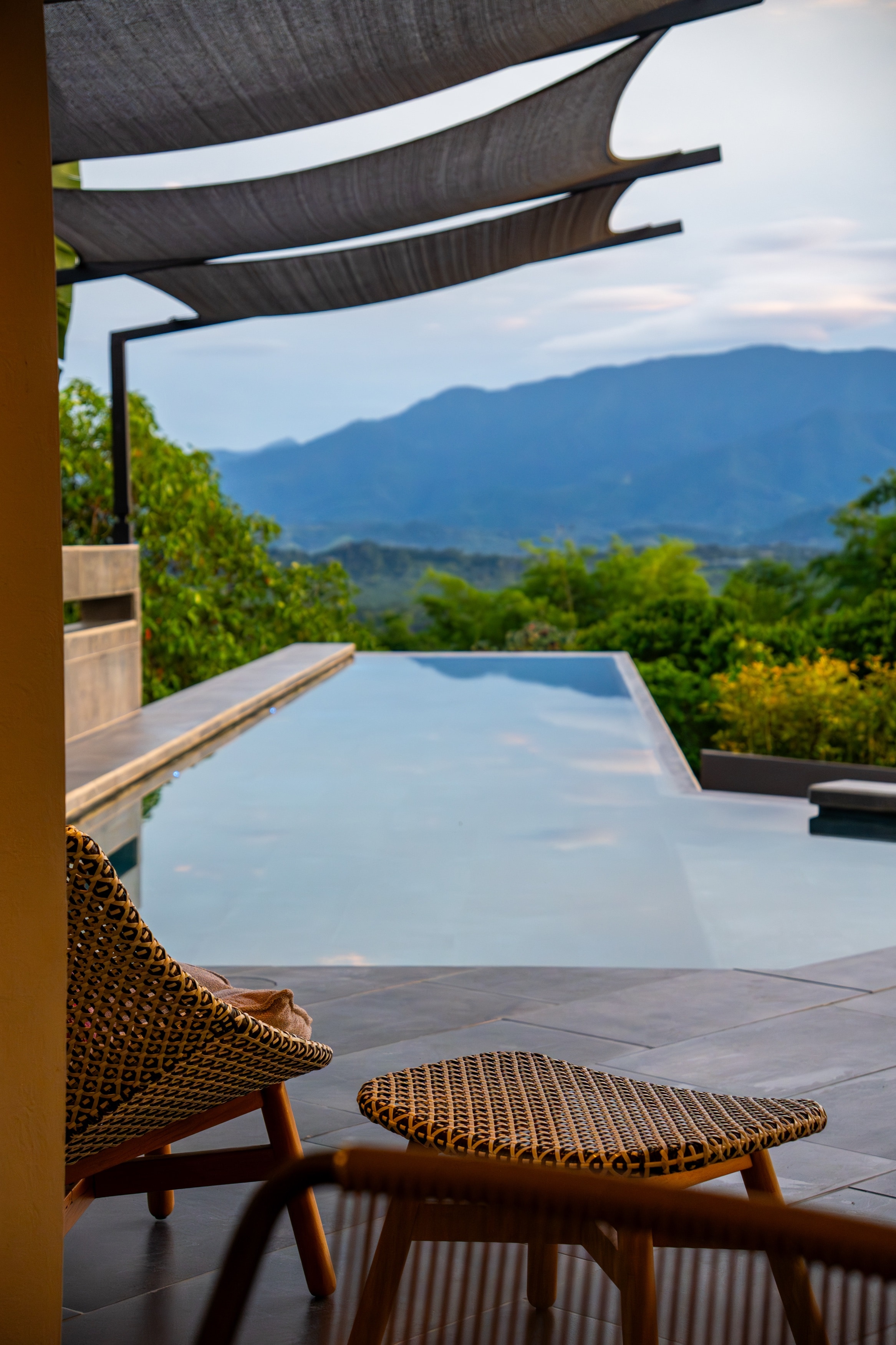 The infinity pool and the mountains beyond, seen from under the terrace shade sails